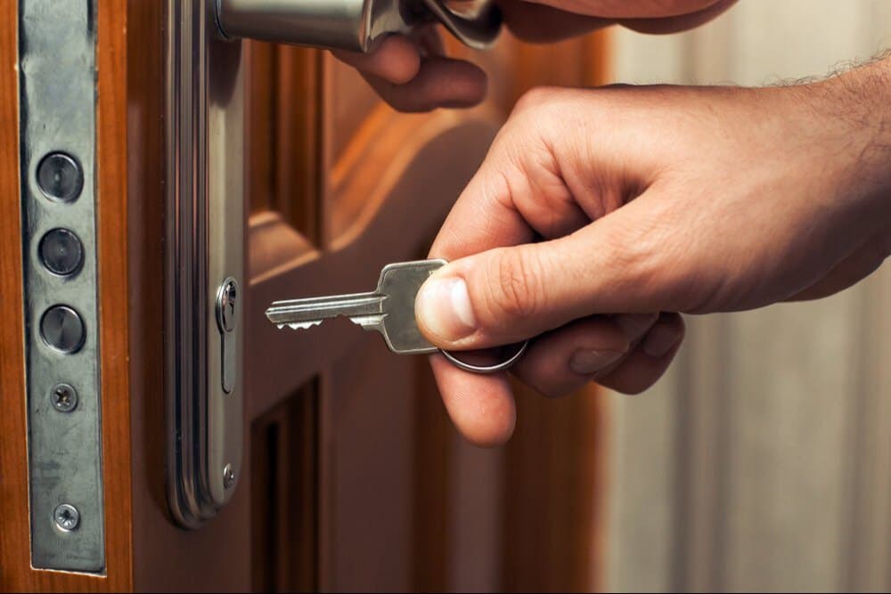 Handyman repairing a door lock on an HDB flat in Singapore